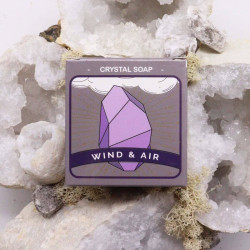Jabón cristal con diseño de piedra púrpura, etiqueta “Crystal Soap” y texto “Wind & Air” sobre fondo gris-lavanda.