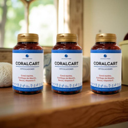 Tres frascos de Coralcart sobre una mesa, etiqueta blanca con texto azul, destaca “CORALCART” y cápsulas.